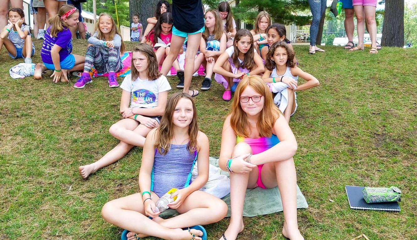 Campers sit on grassy hill
